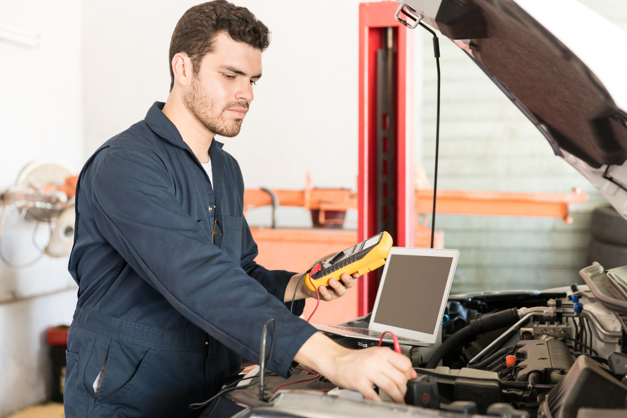 Car Mechanic Checking The Voltage Of Battery Using Voltmeter Car Mechanic Checking The Voltage Of Battery Using Voltmeter